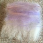 merino wool base layer laid out for felting with a wash of colour for the sky